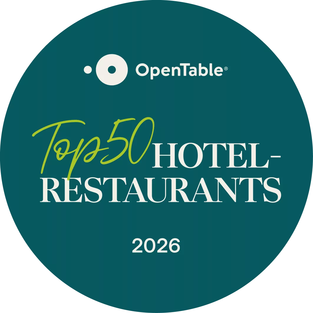 Auf einem runden Abzeichen in dunklem Blaugrün steht in weißer und grüner Schrift „OpenTable Top 50 Hotel-Restaurants 2026“.